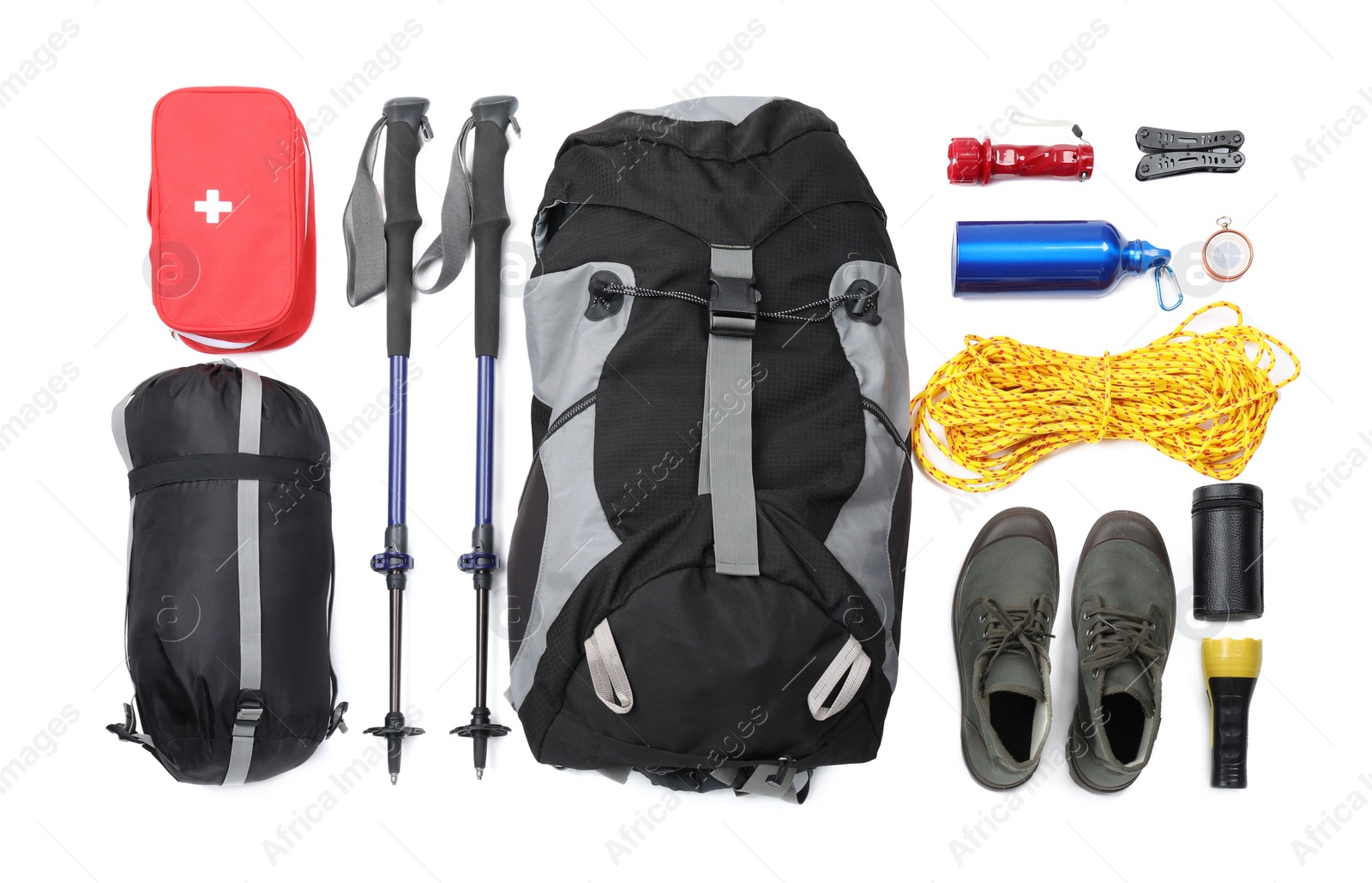 Photo of Pair of trekking poles and camping equipment for tourism on white background, top view