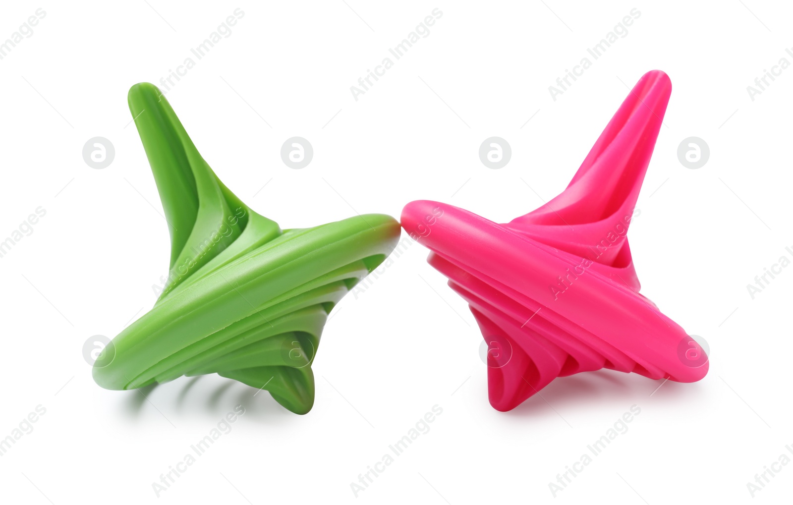 Photo of Green and pink spinning tops isolated on white