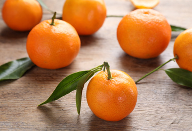 Photo of Tasty fresh ripe tangerines on wooden table