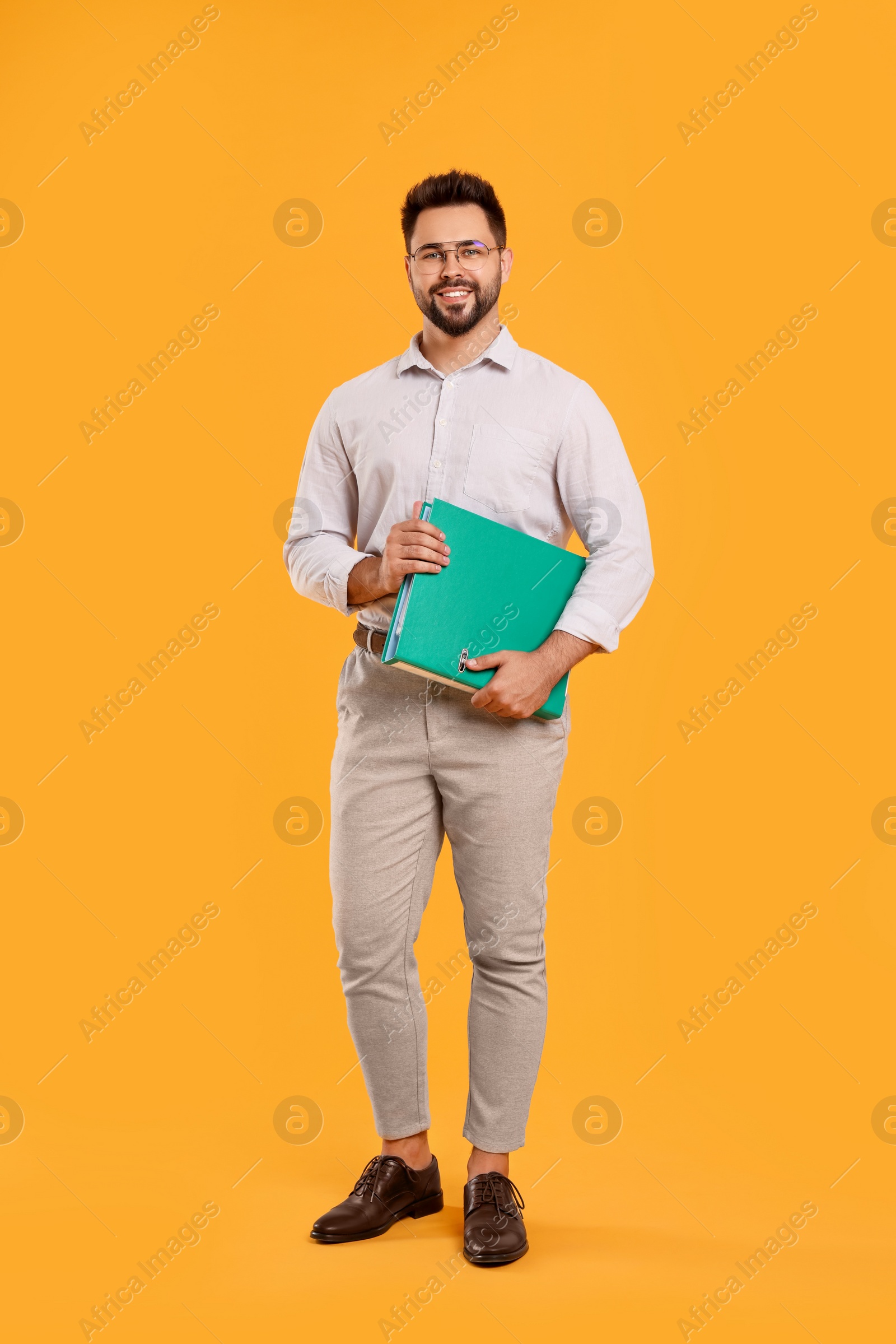 Photo of Happy man with folder on orange background
