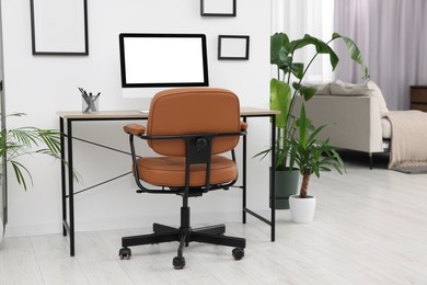 Photo of Stylish room interior with comfortable office chair, desk and houseplants