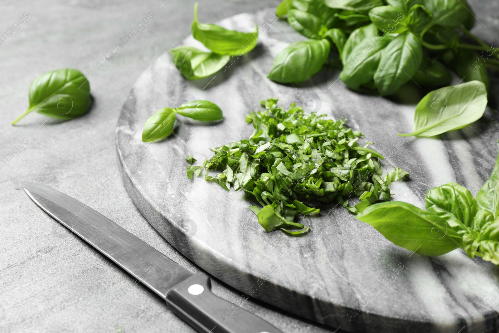 Photo of Fresh green basil on light grey table, closeup