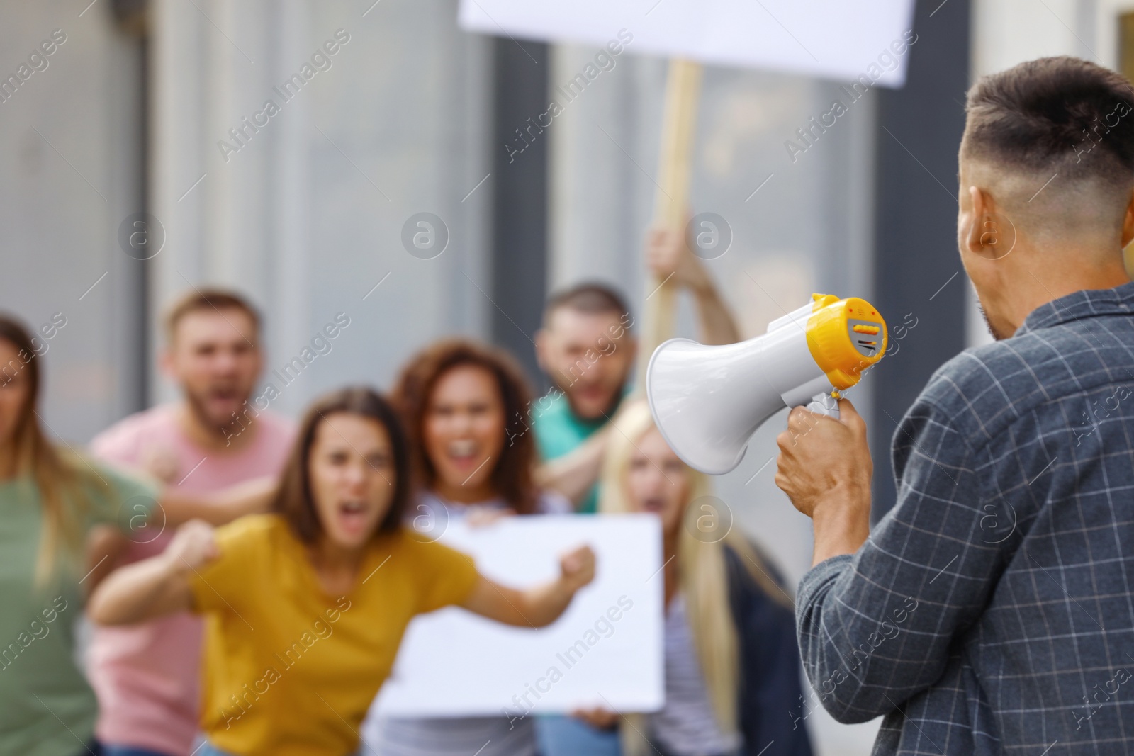 Image of Protest leader with megaphone talking to crowd outdoors