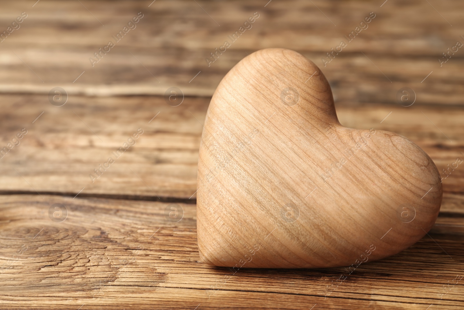 Photo of Decorative heart on wooden table, closeup. Valentine's Day