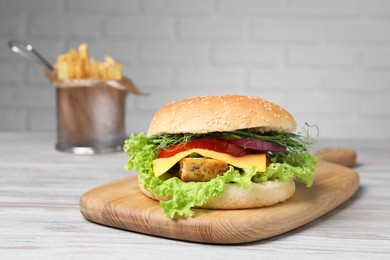 Delicious burger with tofu and fresh vegetables on wooden table