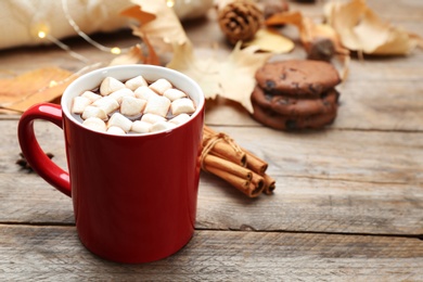 Photo of Cup of hot drink and cookies on wooden table. Cozy autumn atmosphere