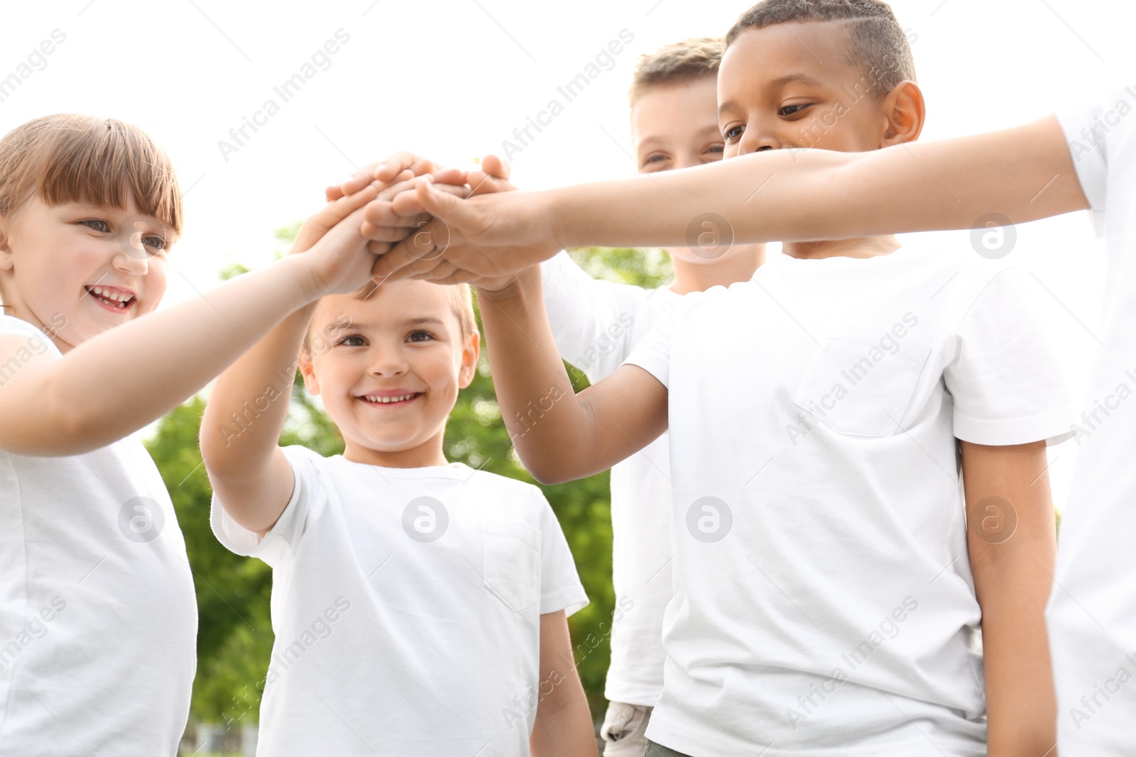 Photo of Group of kids joining hands in park. Volunteer project