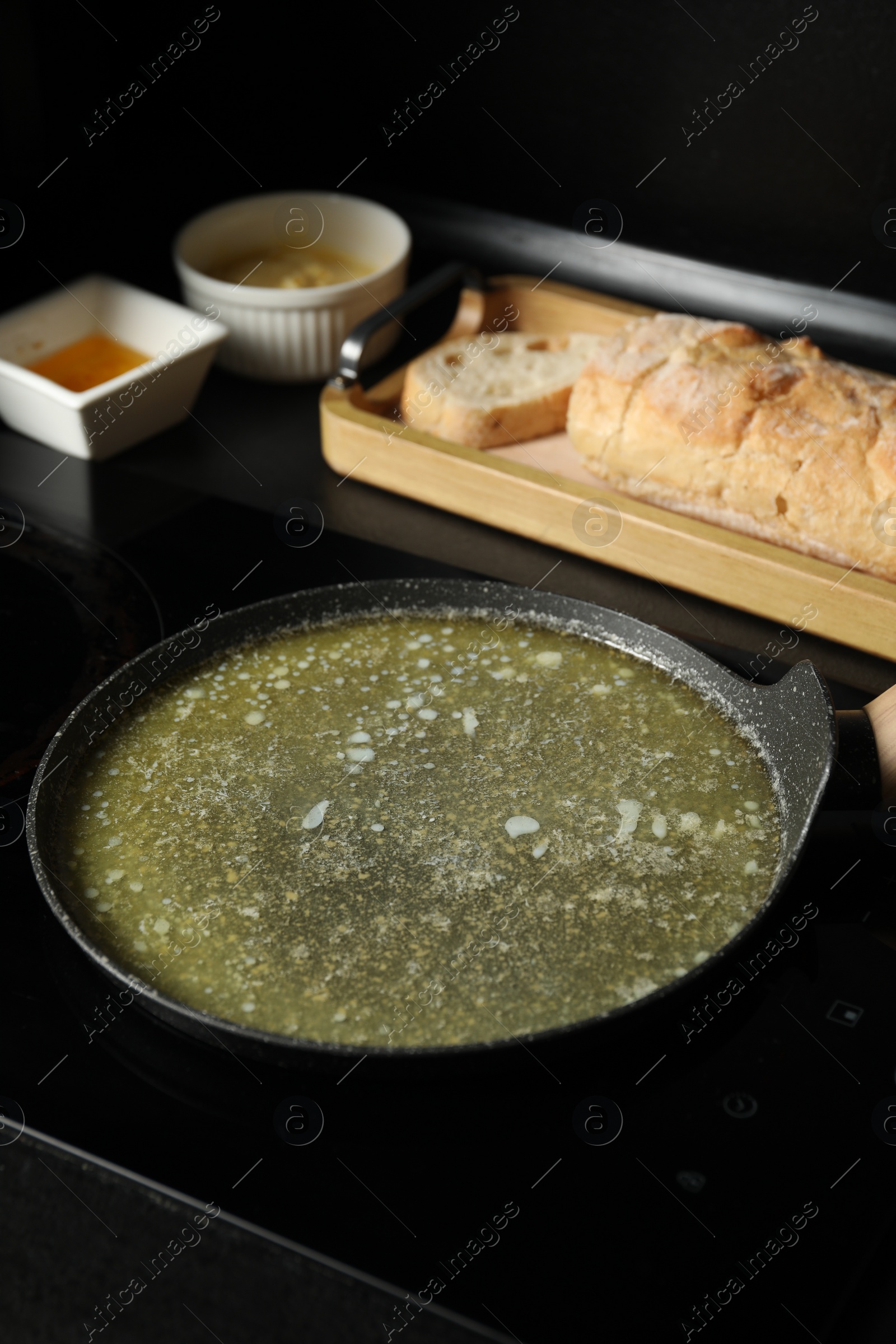 Photo of Melted butter in frying pan on cooktop