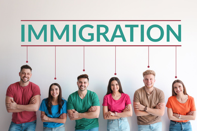 Image of Immigration concept. Group of young people standing near light wall