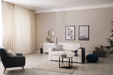 Photo of Stylish living room interior with white sofa, armchair and small coffee table