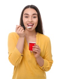 Happy woman eating tasty yogurt on white background