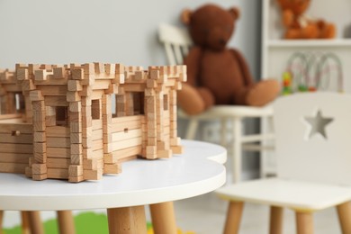 Wooden fortress on white table indoors, space for text. Children's toy