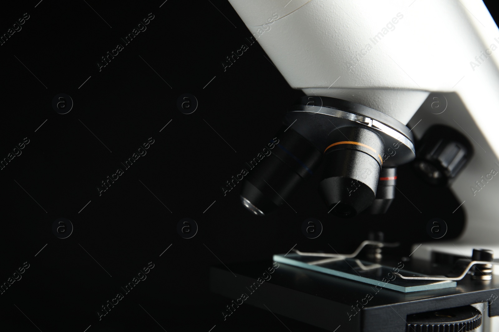 Photo of Closeup view of modern microscope on black background, space for text. Medical equipment