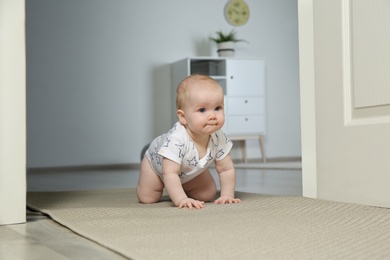Cute little baby crawling on carpet indoors