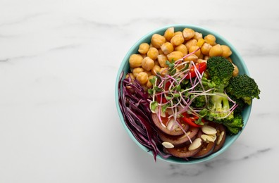 Delicious vegan bowl with broccoli, red cabbage and chickpeas on white marble table, top view. Space for text