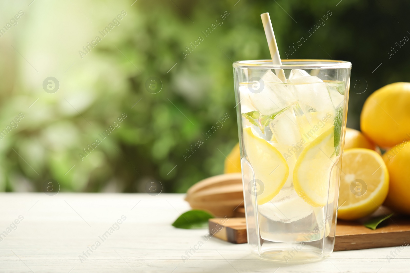 Photo of Cool freshly made lemonade and fruits on white wooden table, closeup. Space for text