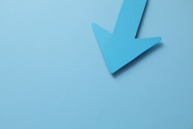 Photo of One paper arrow on light blue background, above view. Space for text