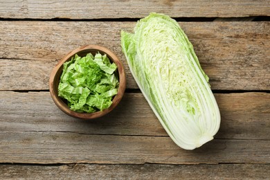 Photo of Whole and cut fresh Chinese cabbages on wooden table, top view