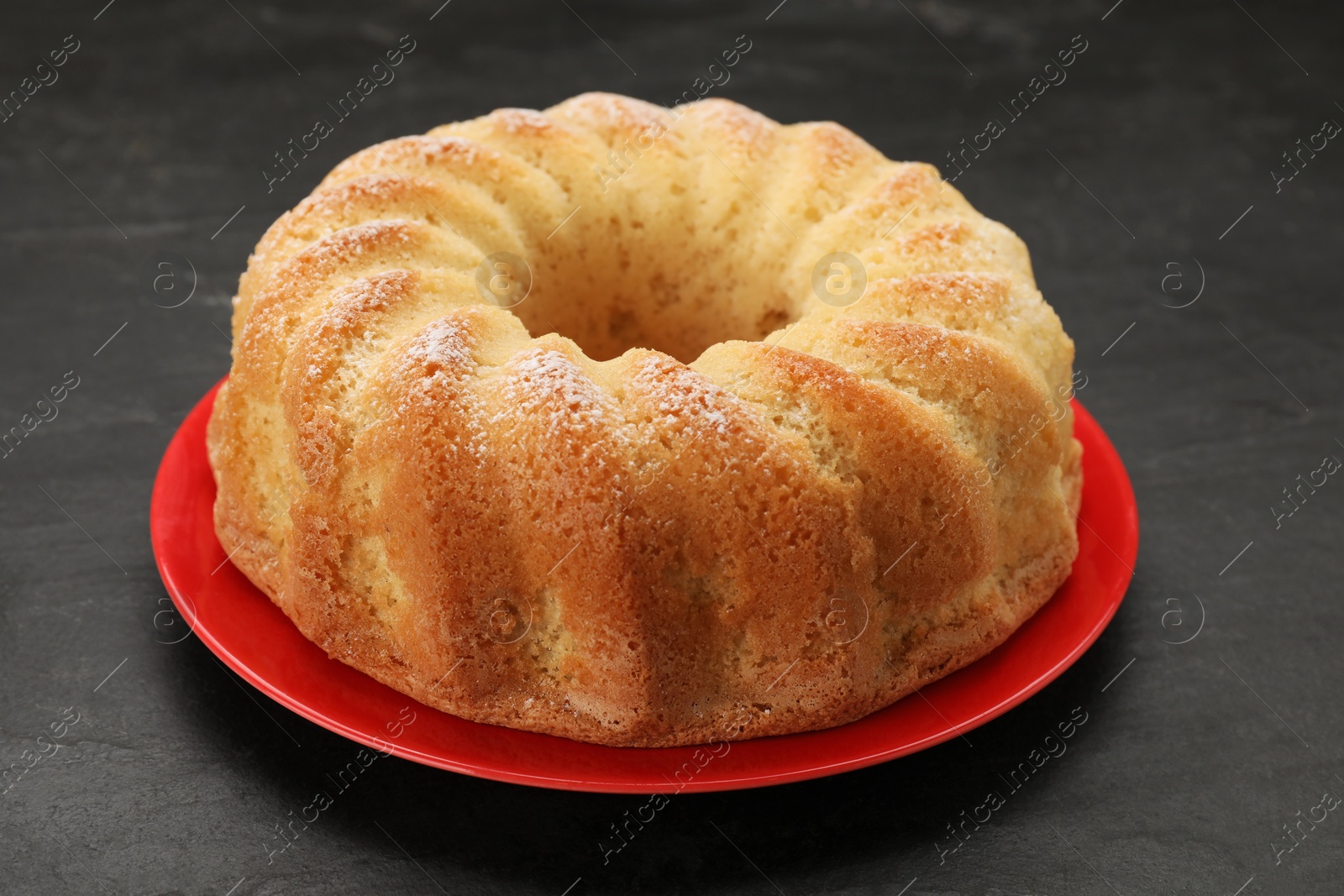 Photo of Delicious freshly baked sponge cake on black table, closeup