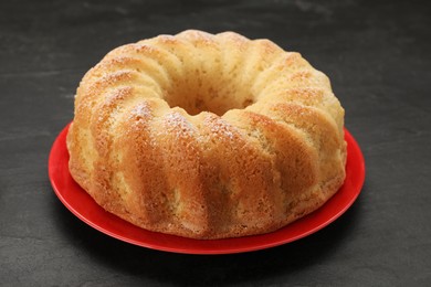 Delicious freshly baked sponge cake on black table, closeup