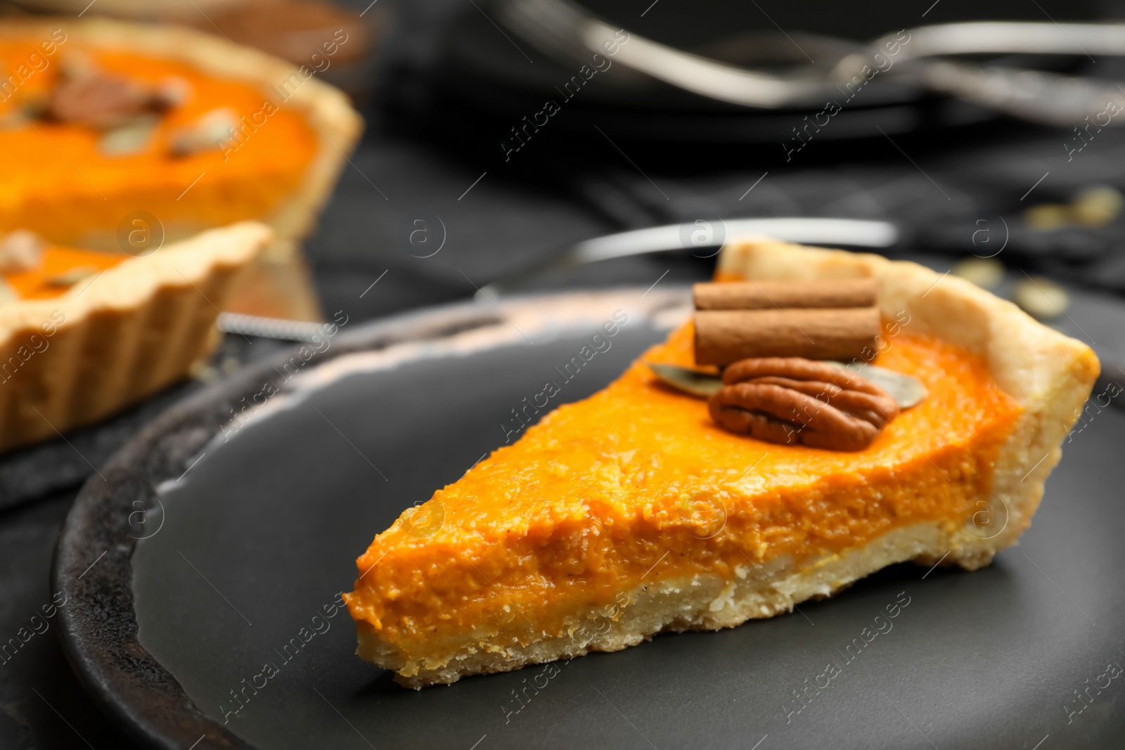 Photo of Slice of delicious homemade pumpkin pie on plate, closeup