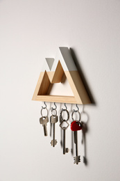 Wooden key holder on light grey wall