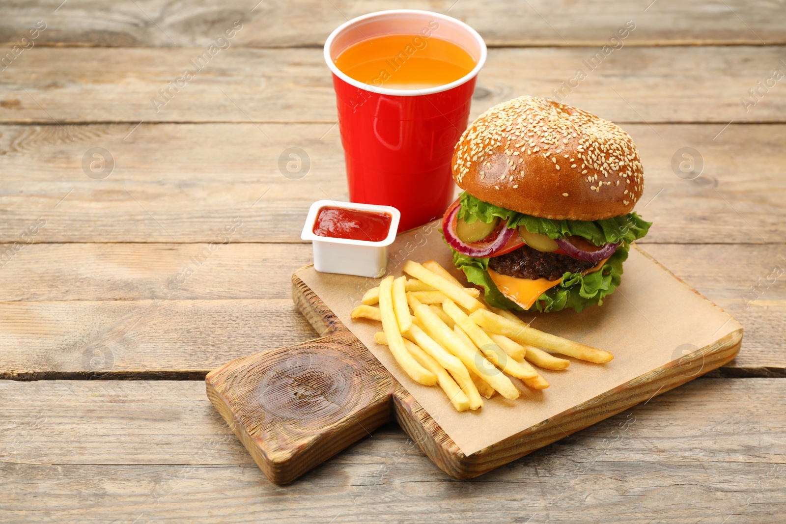 Photo of Burger, French fries, ketchup and refreshing drink on wooden table, space for text. Fast food