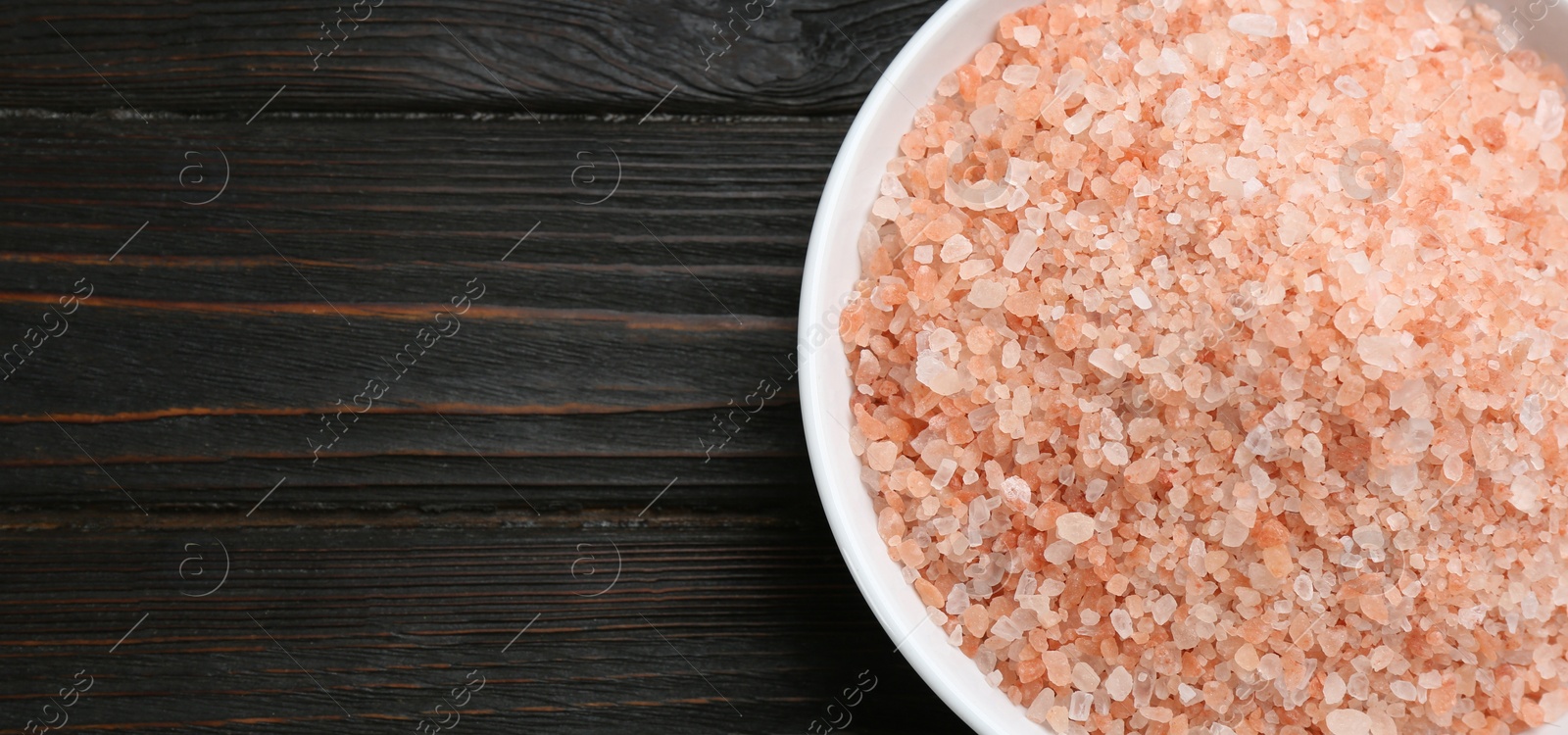 Photo of Pink himalayan salt on wooden table, top view. Space for text