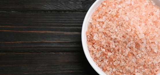 Photo of Pink himalayan salt on wooden table, top view. Space for text