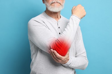Image of Arthritis symptoms. Man suffering from pain in his elbow on light blue background, closeup