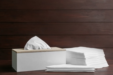 Photo of Box with tissues and napkins on wooden table