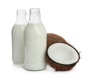 Photo of Bottles with coconut milk and nuts on white background