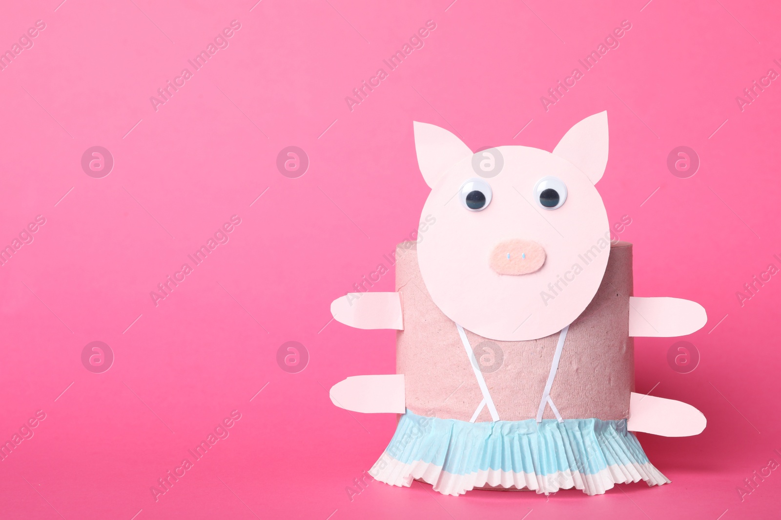 Photo of Toy pig made of toilet paper roll on pink background. Space for text