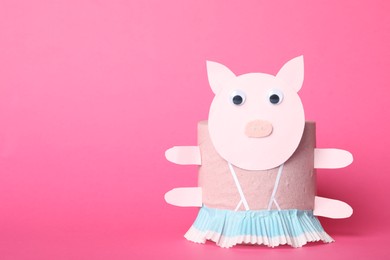 Photo of Toy pig made of toilet paper roll on pink background. Space for text