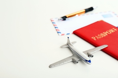 Photo of Toy plane, passport and space for text on white background. Travel insurance