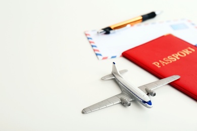 Toy plane, passport and space for text on white background. Travel insurance