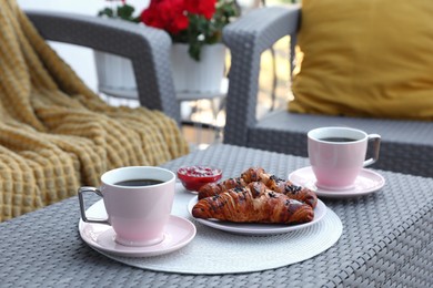 Photo of Outdoor breakfast with tea and croissants on white table on terrace