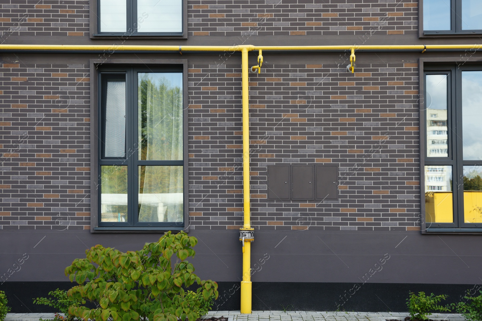 Photo of Yellow gas pipes near brick wall outdoors
