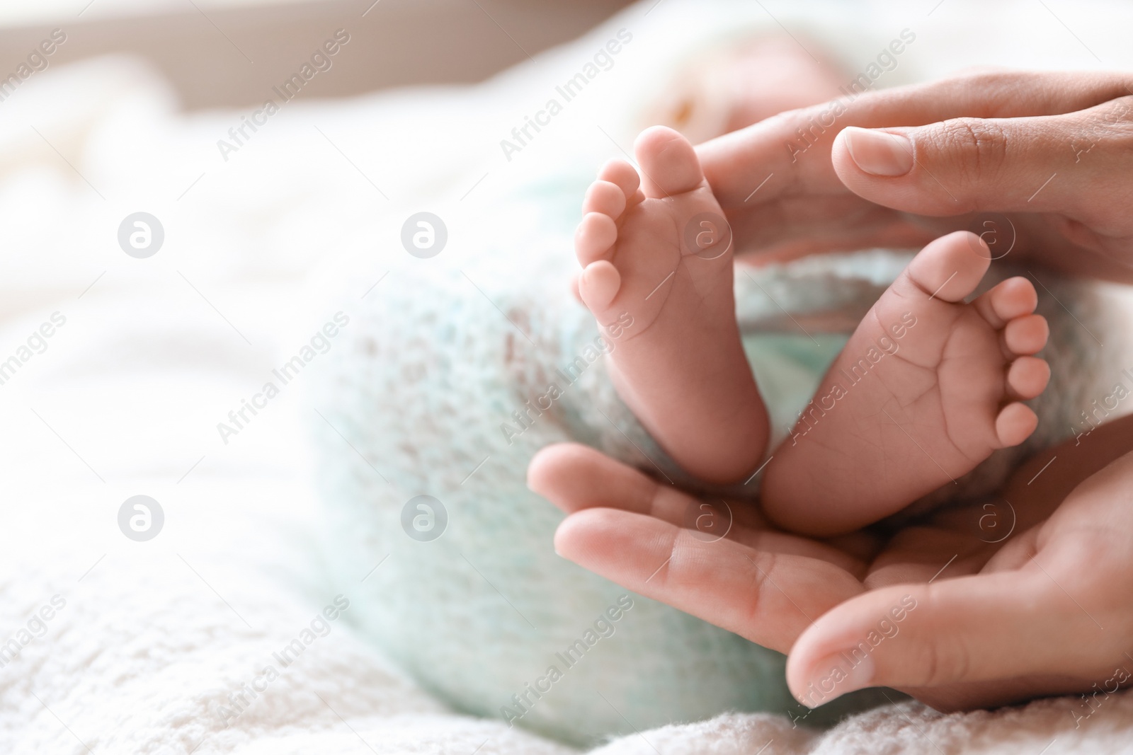 Photo of Mother and her newborn baby on white plaid, closeup