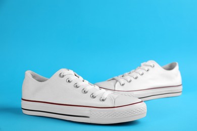 Photo of Pair of trendy sneakers on light blue background