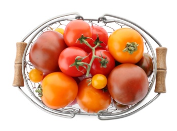 Top view of fresh ripe yellow and red tomatoes in metal basket on white background