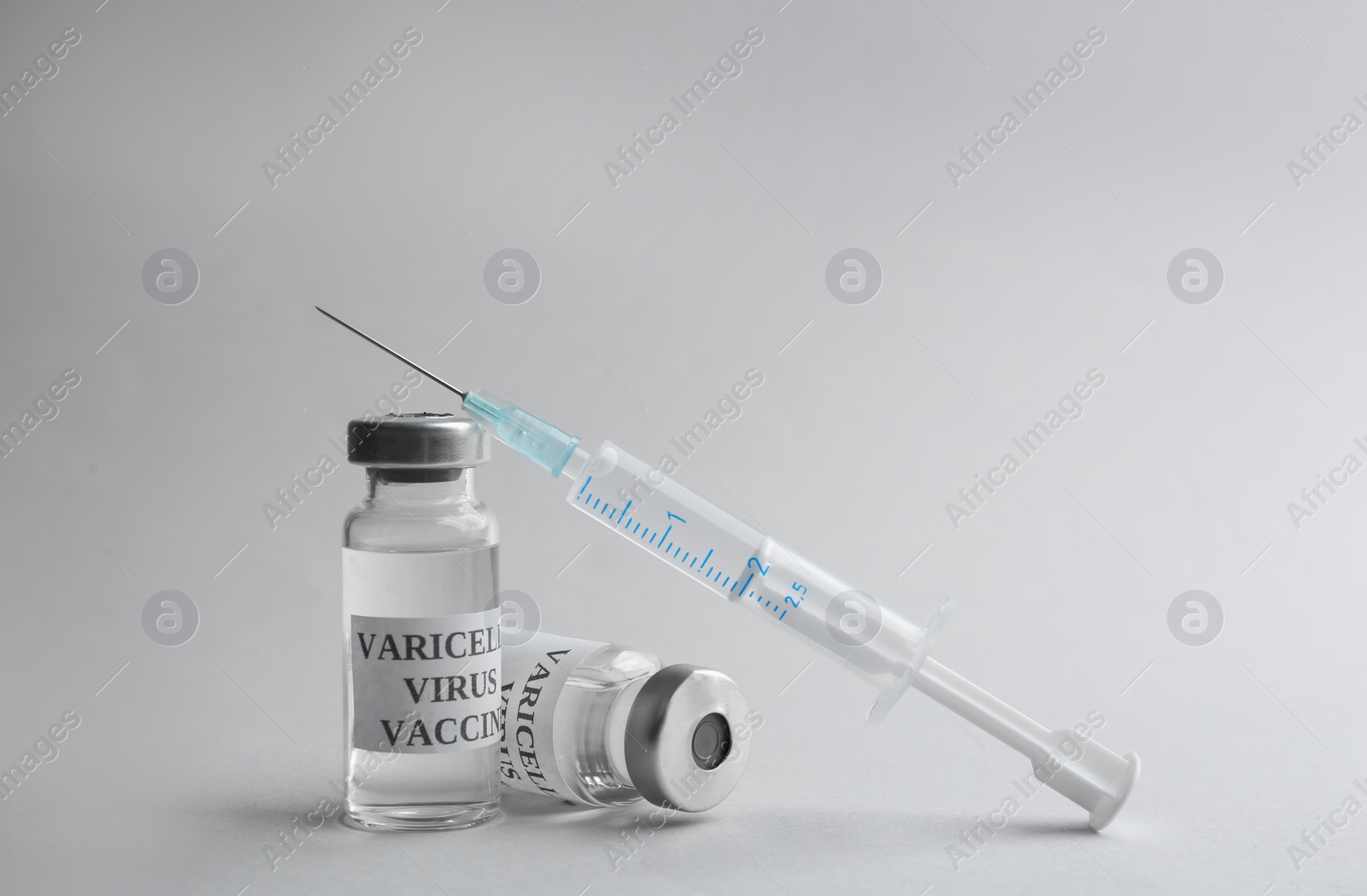 Photo of Chickenpox vaccine and syringe on light grey background. Varicella virus prevention