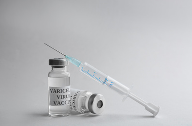 Photo of Chickenpox vaccine and syringe on light grey background. Varicella virus prevention
