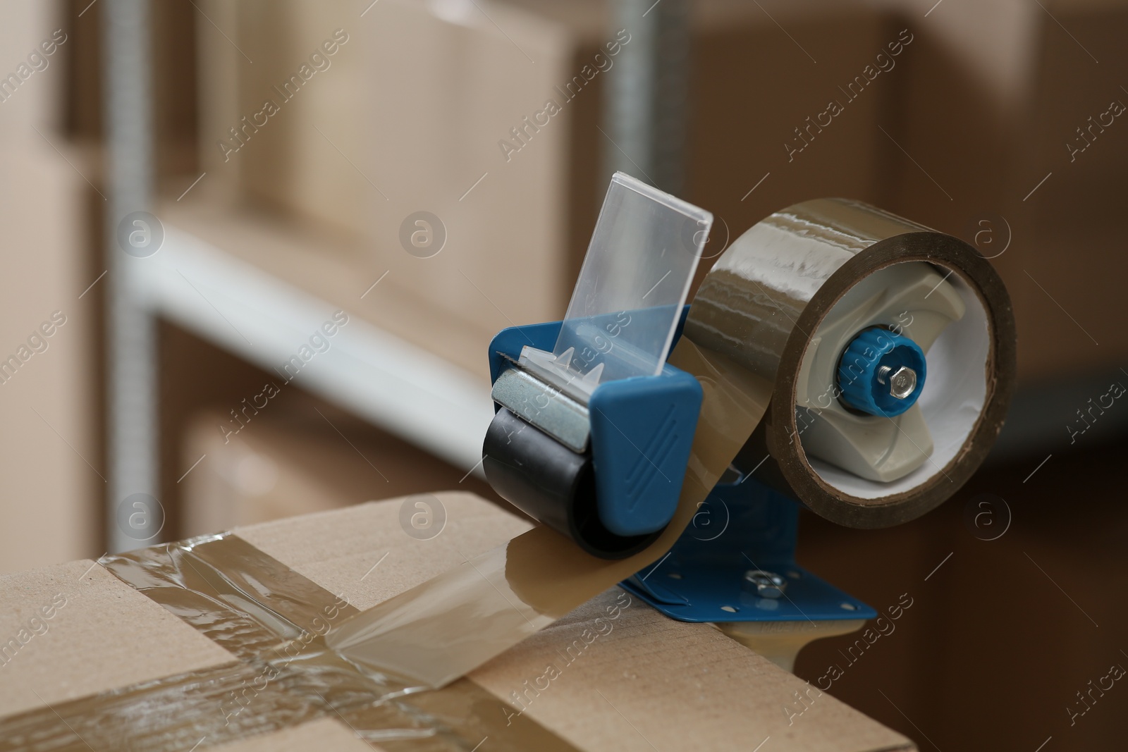 Photo of Taping box with adhesive tape dispenser indoors. Space for text