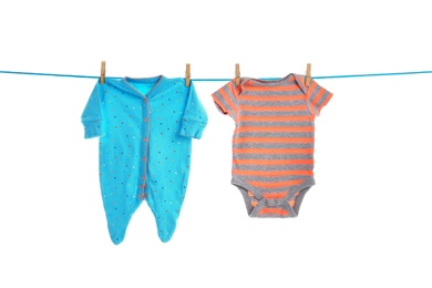 Baby clothes on laundry line against white background