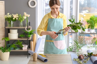 Photo of Female florist pruning roses at workplace