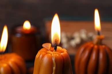 Photo of Burning candles on blurred background, closeup. Autumn atmosphere