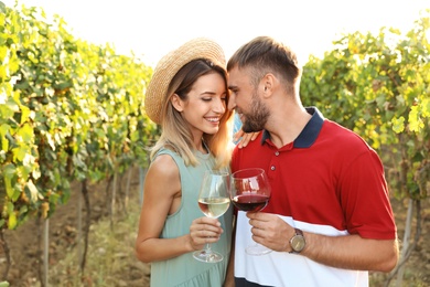 Romantic couple holding glasses of wine at vineyard