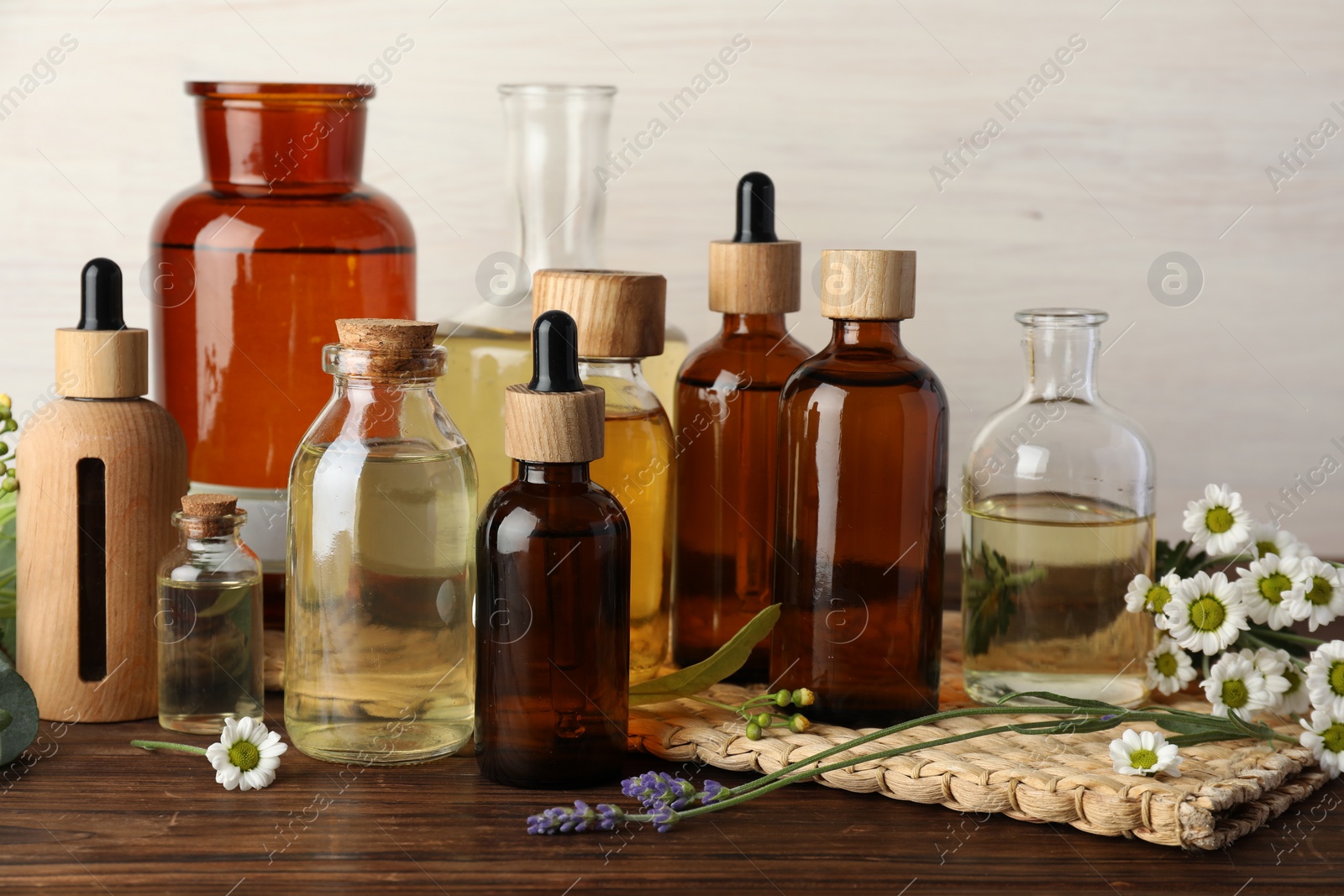 Photo of Aromatherapy. Different essential oils and flowers on wooden table