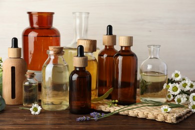 Photo of Aromatherapy. Different essential oils and flowers on wooden table